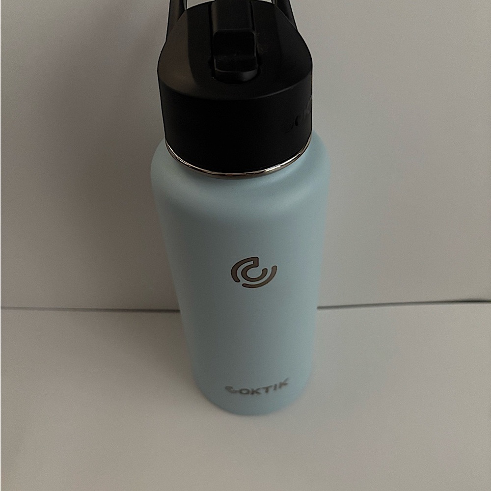 NEVER USED SKY BLUE BOTTLE WITH BLACK LID AND FLIP SPOUT.  32 oz